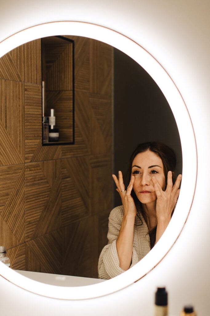 Patient nourishing skin and looking in mirror.