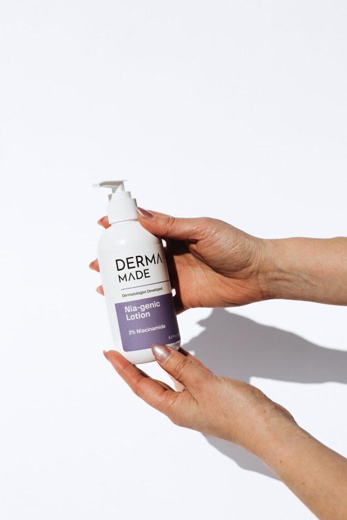 ONYX Beauty Lab | The Onyx Beauty Lab 2025 Holiday Gift Guide Derma Made Nia-Genic Lotion in a bottle is held in hands.