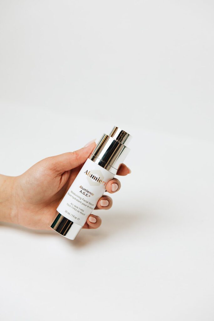 ONYX Beauty Lab | The Onyx Beauty Lab 2025 Holiday Gift Guide Alumier Alumience A.G.E. Product is held in a hand.